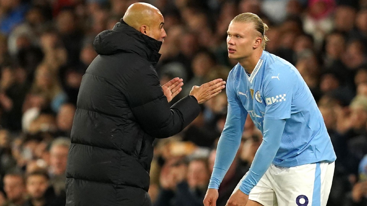 Manchester City manager Pep Guardiola speaks with Erling Haaland