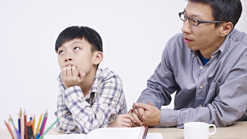 বাবা তার সন্তানকে পড়াচ্ছেন।