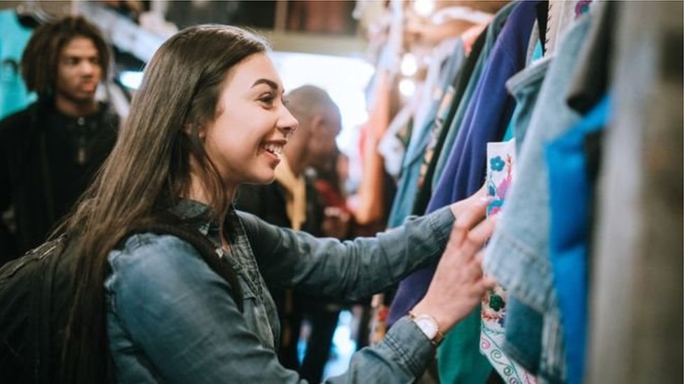 দোকানে পোশাক দেখছেন এক নারী দোকানে পোশাক দেখছেন এক নারী