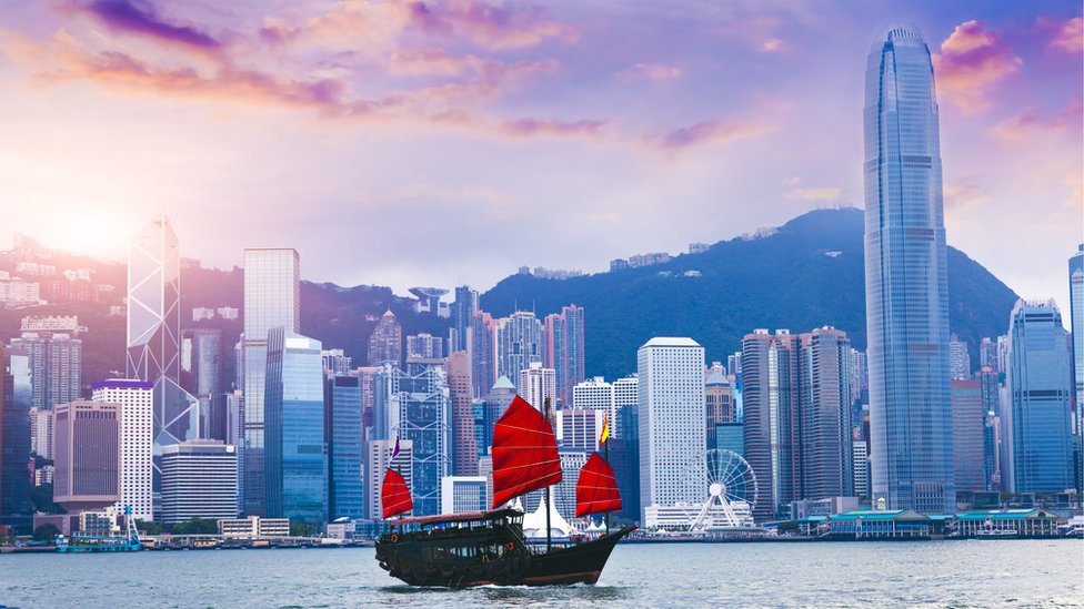 A sailboat travels past Hong Kong Victoria Harbour at sunset (stock picture) A sailboat travels past Hong Kong Victoria Harbour at sunset (stock picture)
