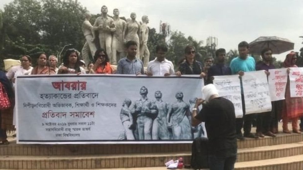 ঢাকা বিশ্ববিদ্যালয়ের রাজু ভাস্কর্য প্রাঙ্গণে বিশ্ববিদ্যালয়ের শিক্ষার্থী এবং শিক্ষকরা বিক্ষোভ করছে