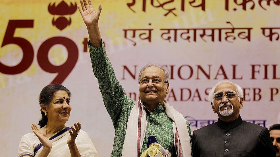 ২০১২ সালে তৎকালীন উপ-রাষ্ট্রপতি হামিদ আনসারির (সর্ব ডানে) কাছ থেকে দাদাসাহেব ফালকে পুরস্কার নেবার পর উপস্থিত অতিথিদের উদ্দেশ্যে অভিবাদন জানাচ্ছেন মি. চট্টোপাধ্যায়