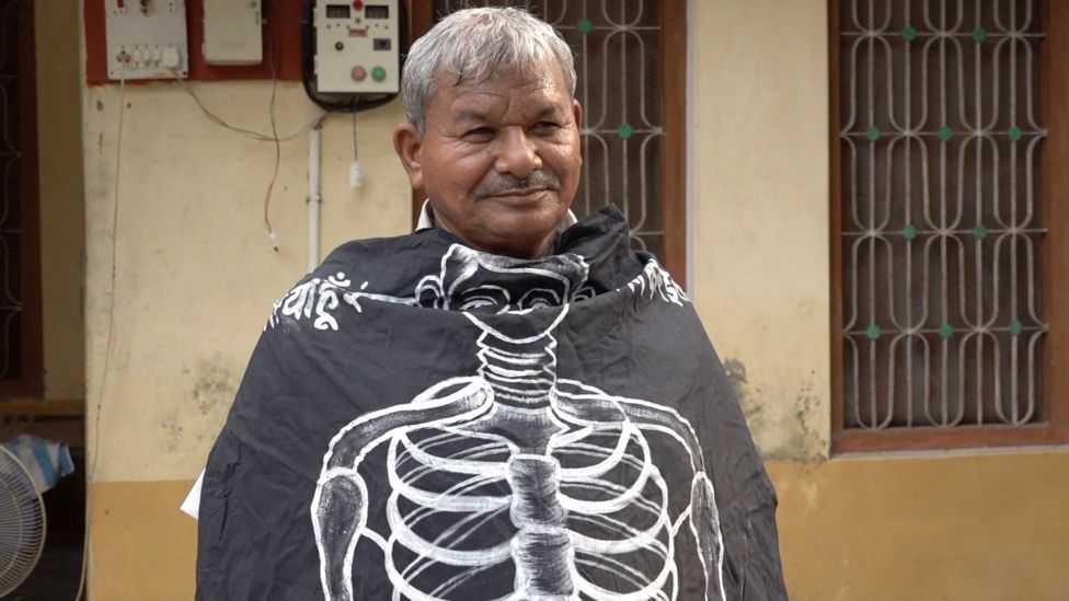 এসোসিয়েশন অব দ্য লিভিং ডেড এর ব্যানার গায়ে লালবিহারি মৃতাক। এসোসিয়েশন অব দ্য লিভিং ডেড এর ব্যানার গায়ে লালবিহারি মৃতাক।