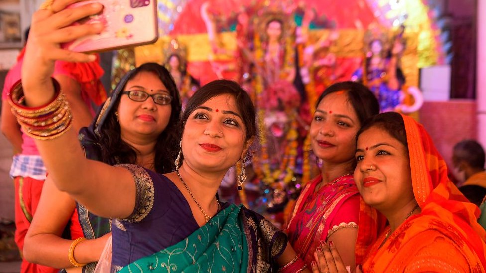 ভারতের একটি পুজা মণ্ডপে সেলফি তুলছেন ভক্তরা (ফাইল ফটো) ভারতের একটি পুজা মণ্ডপে সেলফি তুলছেন ভক্তরা (ফাইল ফটো)
