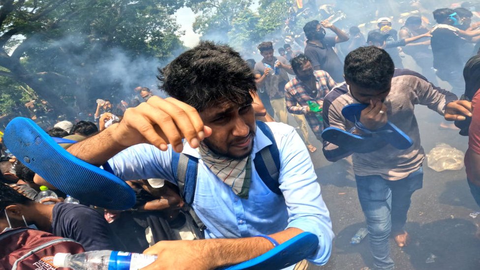 কলম্বোয় প্রধানমন্ত্রীর দপ্তরের ফটক ভেঙে ভেতর ঢোকার চেষ্টার সময় বিক্ষোভকারীদের লক্ষ্য করে পুলিশ কাঁদানে গ্যাস ছোঁড়ে