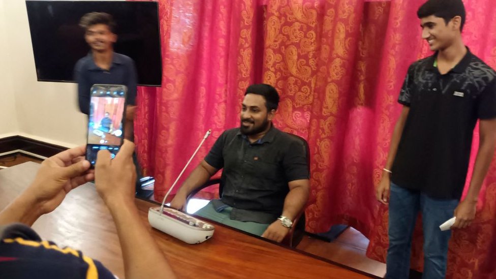 কলম্বোতে গণবিক্ষোভে প্রেসিডেন্টের প্রাসাদ তছনছ হওয়ার পর মি. রাজাপাকশার চেয়ারে বসে ছবি তুলছেন একজন অজ্ঞাতনামা বিক্ষোভকারী। কলম্বোতে গণবিক্ষোভে প্রেসিডেন্টের প্রাসাদ তছনছ হওয়ার পর মি. রাজাপাকশার চেয়ারে বসে ছবি তুলছেন একজন অজ্ঞাতনামা বিক্ষোভকারী।